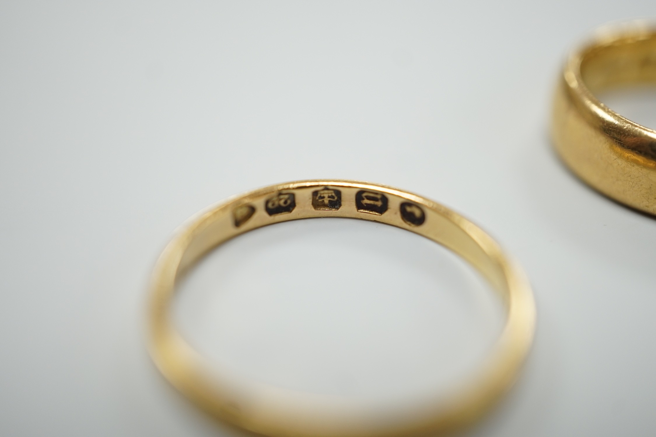 A thin Victorian 22ct gold wedding band, London, 1875, size K/L and two later 22ct gold wedding bands, including Edwardian (1901), size I, and Elizabeth II (1969), size N, 11.1 grams.